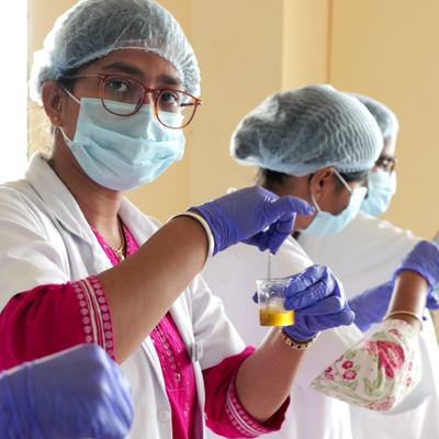 Scientists in lab coats and protective gear conducting experiments.